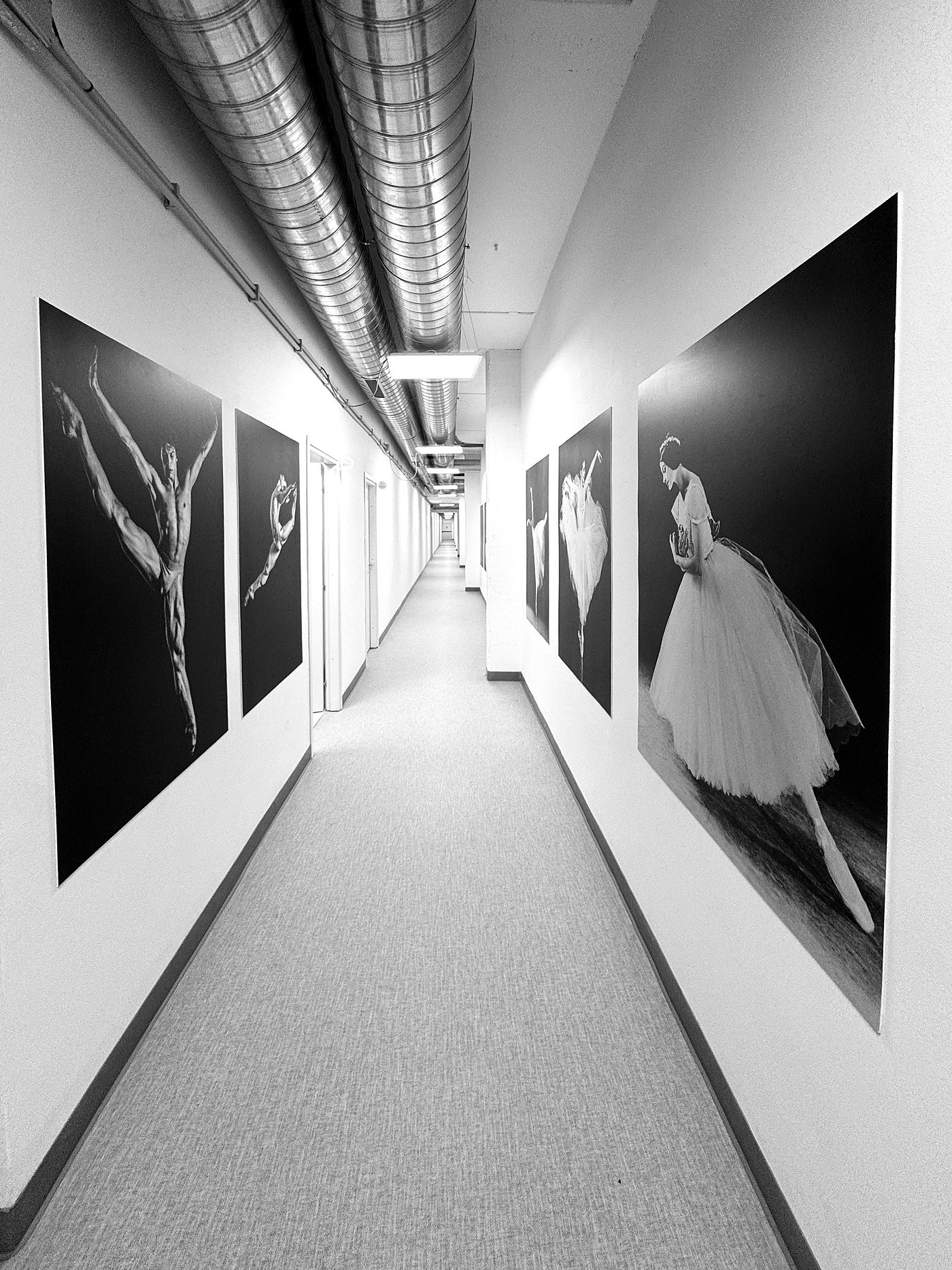 Il corridoio di UNA DANZA, con le grandi fotografie di danza in bianco e nero alle pareti